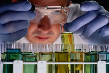 a man in a lab coat is holding a test tube